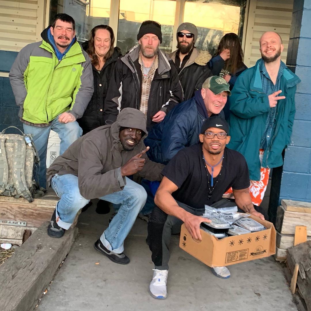 A group of nine people receive a box of food courtesy of MenuBubble